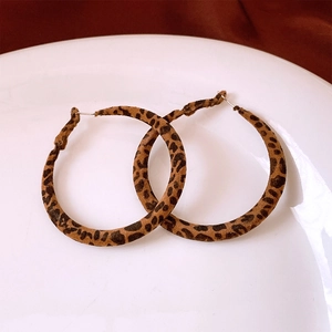Detailed view of leopard print flocking hoop earrings resting on a white ceramic plate