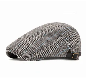 Close-up of grey plaid flat cap fabric with blue stripes and adjustable side strap