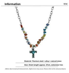 Detail view of silver curb chain with colorful natural stones and blue heart cross pendant