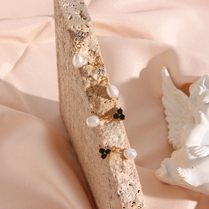 Detail of freshwater pearl earrings with three-stone zircon setting on a vintage stone base