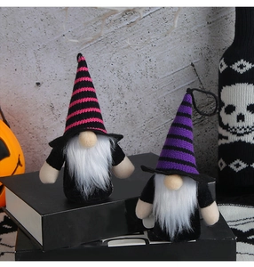 Close-up of Halloween gnomes with striped hats on books with pumpkin and skull decor