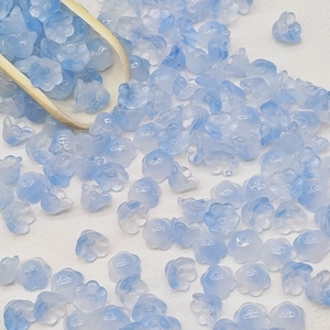 Detailed close-up of light blue lily-of-the-valley glass beads for DIY jewelry making