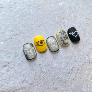 Makro-Detail von 5D-Nagelstickern mit handgeschriebenen Sätzen und handgezeichneten Mustern