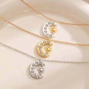 Detailed view of three sun and moon opal necklaces on a ceramic tray in gold and silver