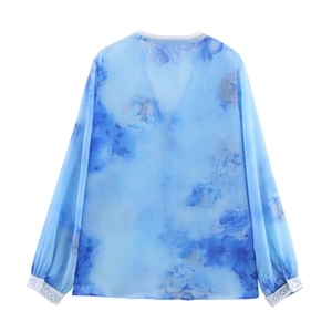 Vista posteriore della camicetta in chiffon blu a fiori con pizzo bianco e maniche a sbuffo