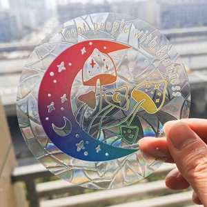 Rainbow suncatcher sticker featuring moon and mushroom designs with star cutouts on glass