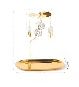 Macro detail of golden spinning candle holder featuring intricate dreamcatcher charms
