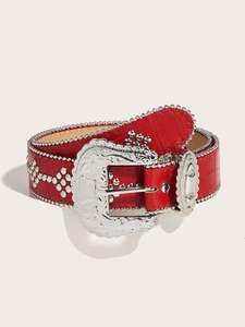 Detail of red crocodile skin belt with vintage floral silver buckle and metal stud trim
