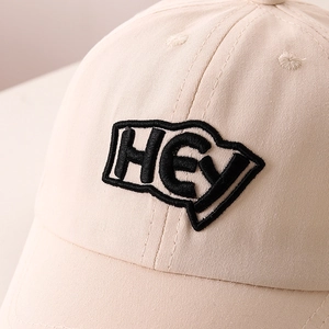 Detail of beige cotton baseball cap featuring high-quality HEY letter embroidery
