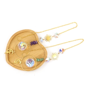 Golden sun and moon crystal suncatcher with clear beads and prisms on a wooden heart tray