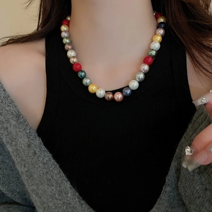 Detail view of colorful pearl necklace worn by a model showcasing vibrant multi-color beads