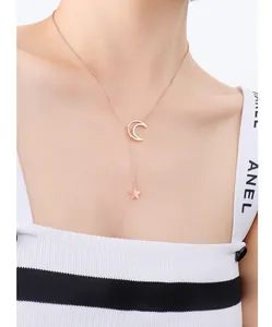 Close-up of rose gold Y-shaped necklace featuring celestial moon and star charms