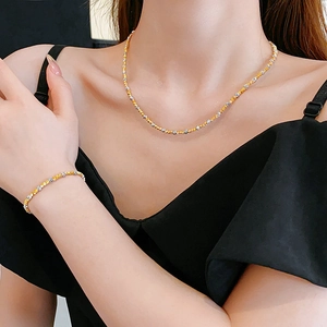 Detail showing mixed gold and silver bead necklace and bracelet set on a model