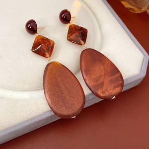 Macro view of vintage earrings with red beads, resin tortoiseshell and wooden teardrop drops