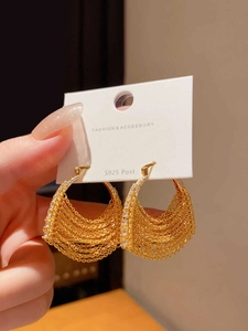 Détail de boucles d'oreilles pompon en or 18k avec zircone et tige en argent S925