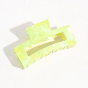 Detailed view of lemon yellow hair claw clip with marble texture and cut-out design