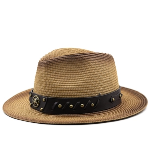 Detail of woven straw fedora with brown leather band and golden horse emblem