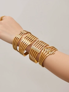Dettaglio di bracciali in acciaio inossidabile dorato con strass e albero della vita