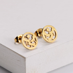Minimalist gold fairy earrings in circular hollow design on white wood display