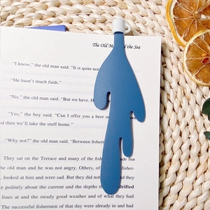 Blue leather spilled coffee bookmark shown inside an open book in a cozy reading setting