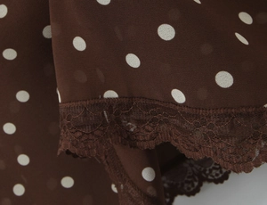 Vue détaillée du tissu mousseline marron café à pois blancs et bordure en dentelle fine