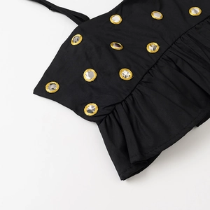 Vue détaillée du tissu noir avec miroirs shisha, broderie dorée et plis accordéons élégants