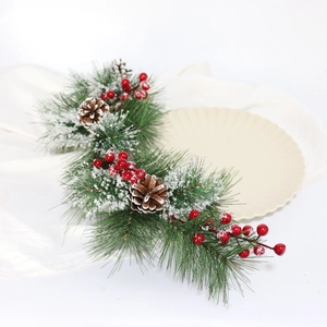 Close-up of frosted pine needles with red berries and natural cones for Christmas decor
