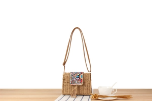 Détail d'un sac en corde de papier tissé main avec perles colorées et décor de pompons