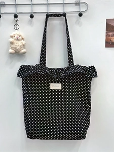 Black polka dot canvas tote bag with ruffle edges and SOKARA STUDIO label