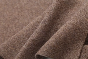 Vista macro dettagliata del morbido tessuto a maglia marrone con trama calda e fibre di lana