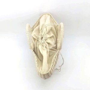 Detailed top view of beige straw bag showing natural fiber texture and drawstring lining