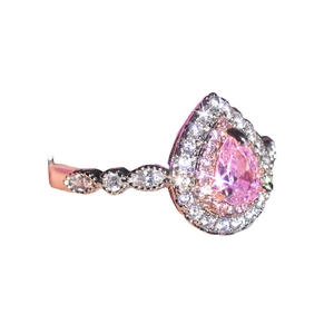Pear cut pink moissanite halo ring in rose gold finish with accent stones