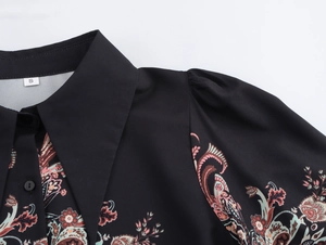 Detail of V-neck collar and ethnic print on a black long sleeve chiffon blouse