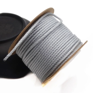 Detailed view of gray 1.5mm braided cotton cord wound on a brown spool for DIY crafts