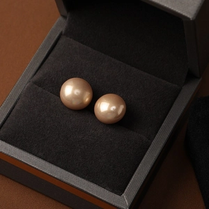 Detailed close-up of champagne gold pearls in a premium black velvet jewelry gift box