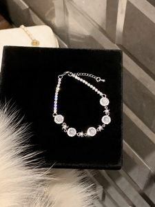 Detail of silver chain bracelet featuring white round stones and star-shaped connectors