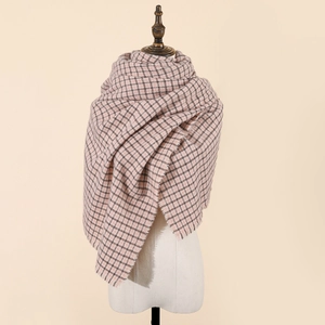 Close-up of soft pink and gray checkered scarf featuring decorative fringe tassels