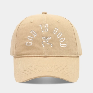 Detailed view of God Is Good text and bow embroidery on khaki cotton baseball cap