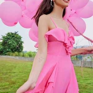Detail of vibrant pink tiered ruffle dress with elegant shoulder straps and layered hem