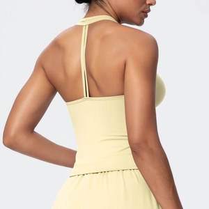 Detail of light yellow yoga sports bra showing slim crisscross back straps and soft fabric