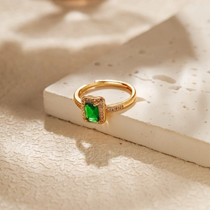Detail view of gold adjustable ring with emerald green zircon stone and shadow lighting