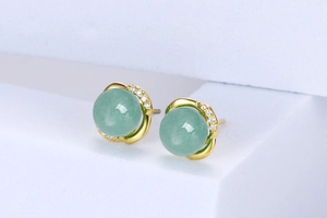 Close-up of S925 silver earrings with green aventurine stones and gold flower setting