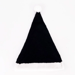 Detail of plush black Christmas hat with white faux fur trim and pompom on white backdrop
