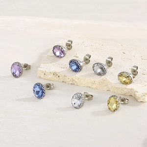 Detail of round rhinestone stud earrings in purple, blue, clear and gold on stone base