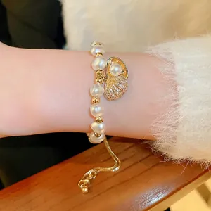 Elegant zircon shell pearl bracelet with adjustable gold chain on wrist