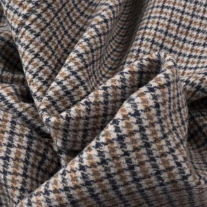 Gros plan sur la texture de laine à carreaux marron et beige pour manteaux