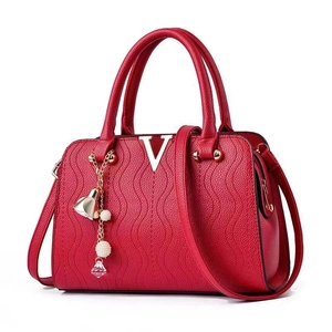 Red embossed leather handbag for women featuring gold V hardware and pearl tassel detail