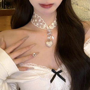 Detailed view of a white lace choker featuring sparkling rhinestones and heart pendant