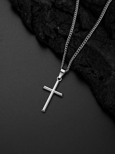 Pendentif croix en argent poli sur fond de pierre naturelle sombre avec chaîne en métal