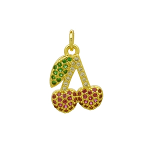 Macro detail of gold-plated cherry pendant featuring vibrant red and green crystals